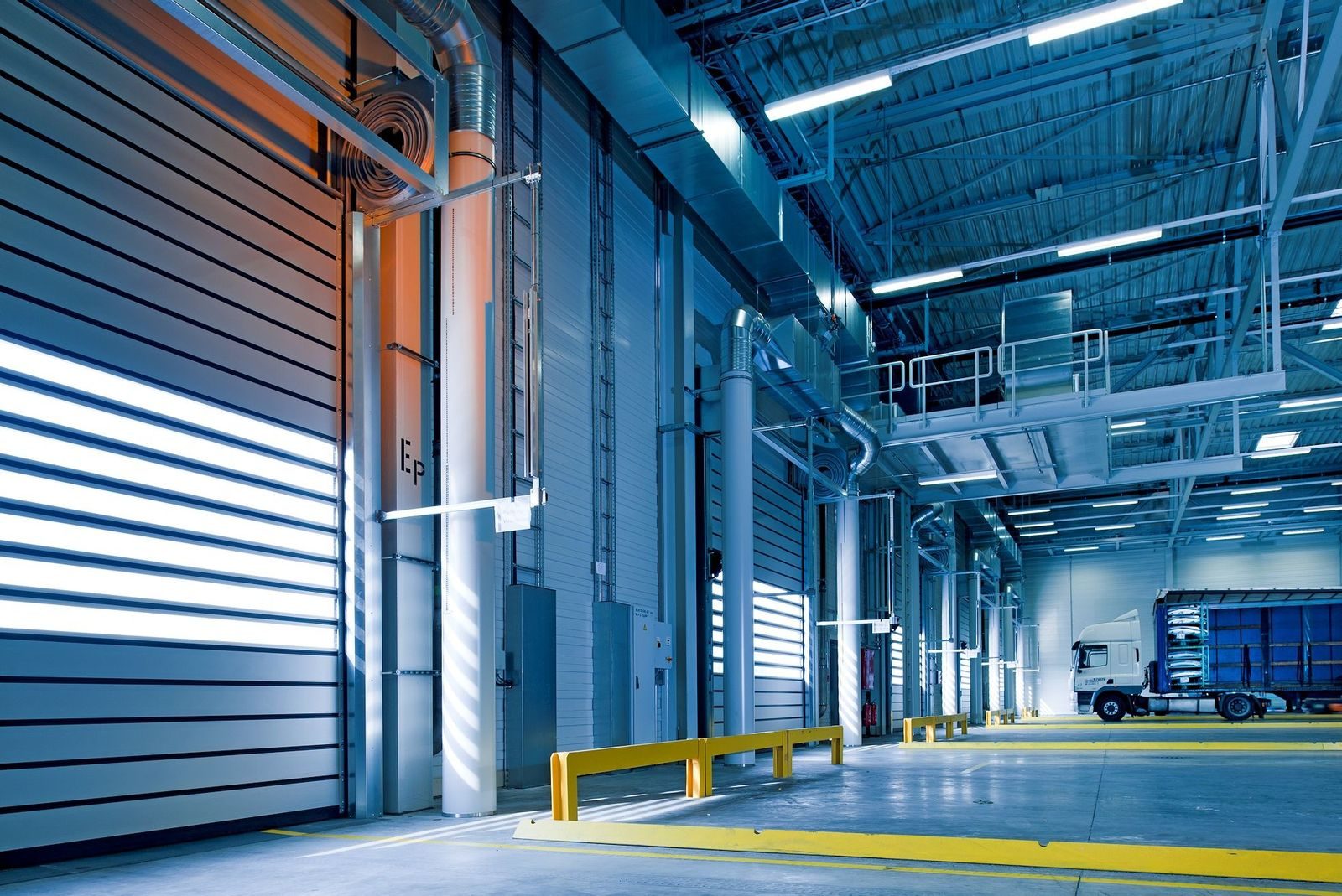 A tractor-trailer parked inside a warehouse loading bay